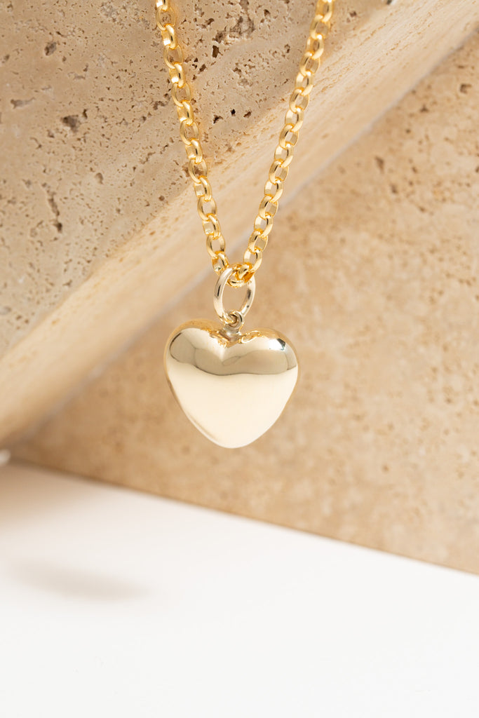 Large 9ct gold puff heart pendant, hanging from a gold belcher chain.