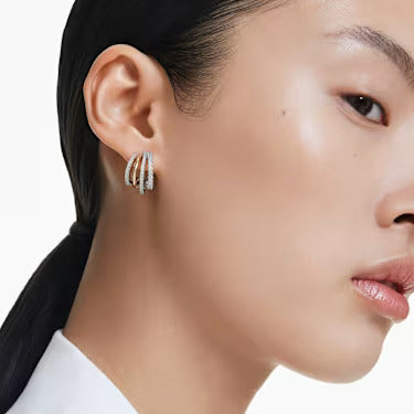 A model is wearing the Swarovski Hyperbola hoop earrings