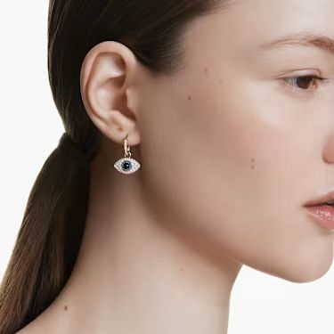 A model is wearing evil eye drop earrings